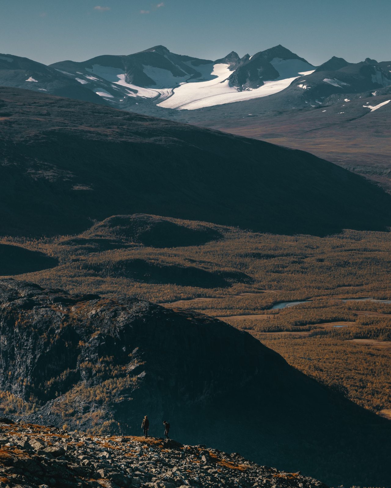 Hikers on a ridge above a glaciated mountain valley