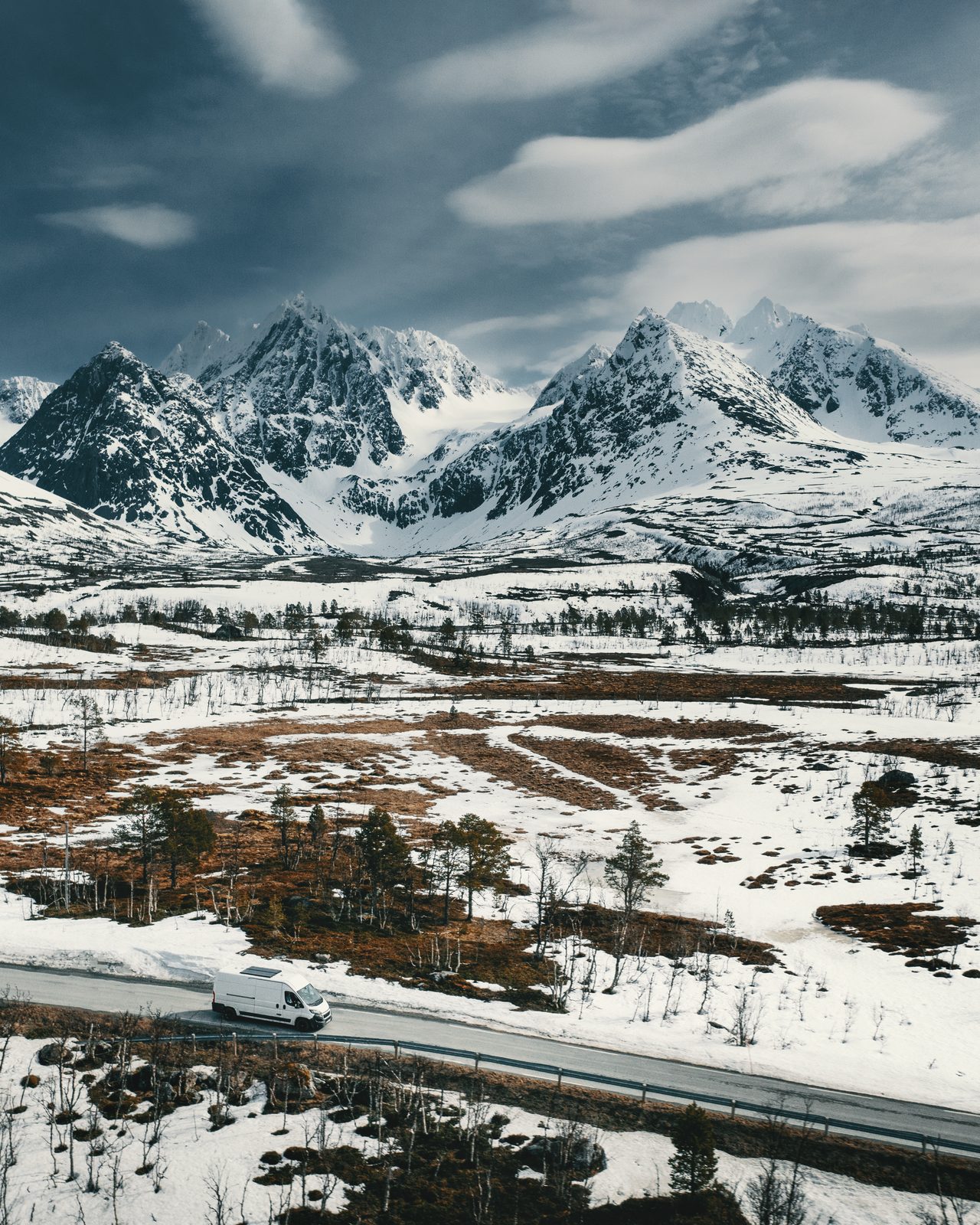 Van on a road below snowy peaks