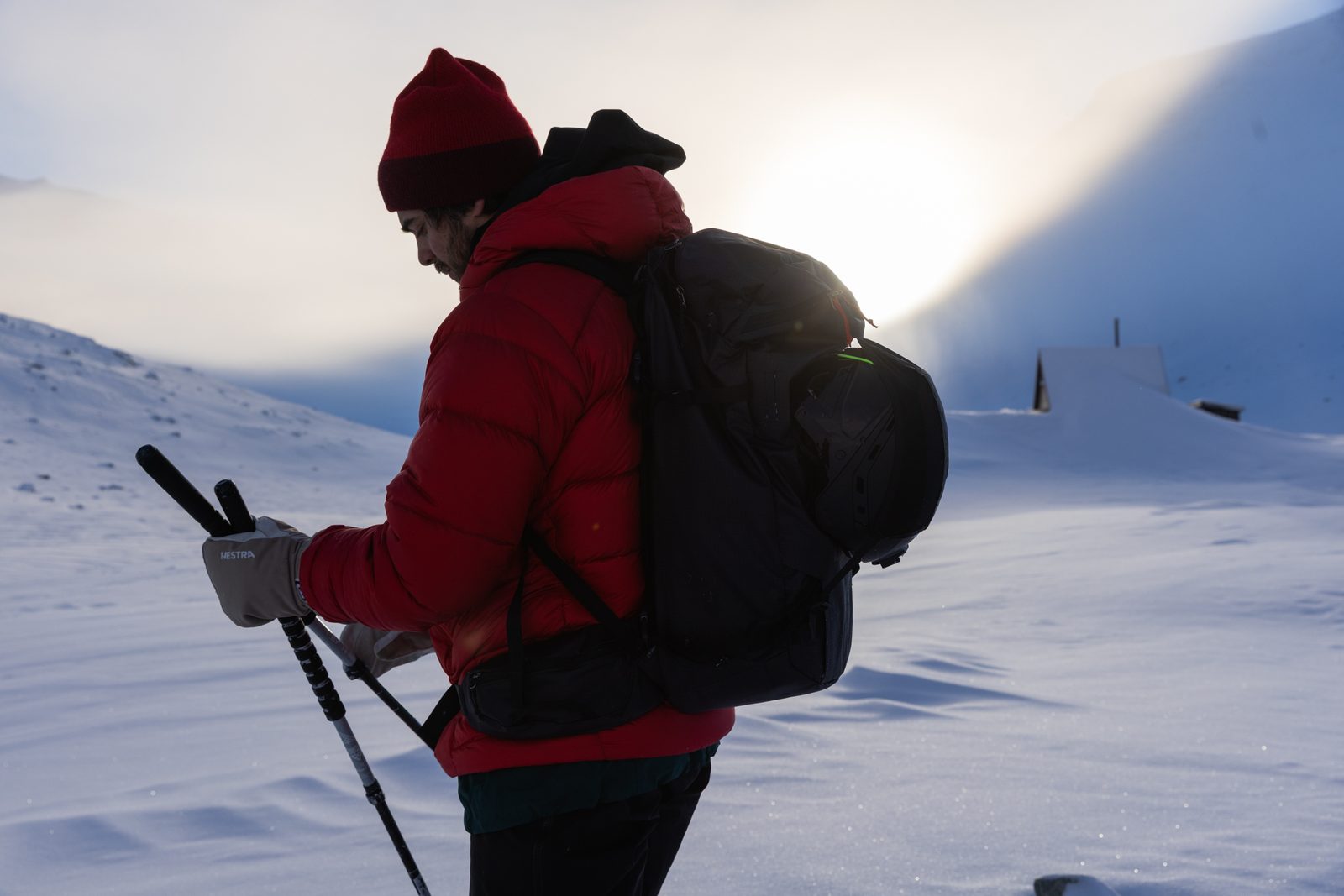 Skier in a red jacket against low sun