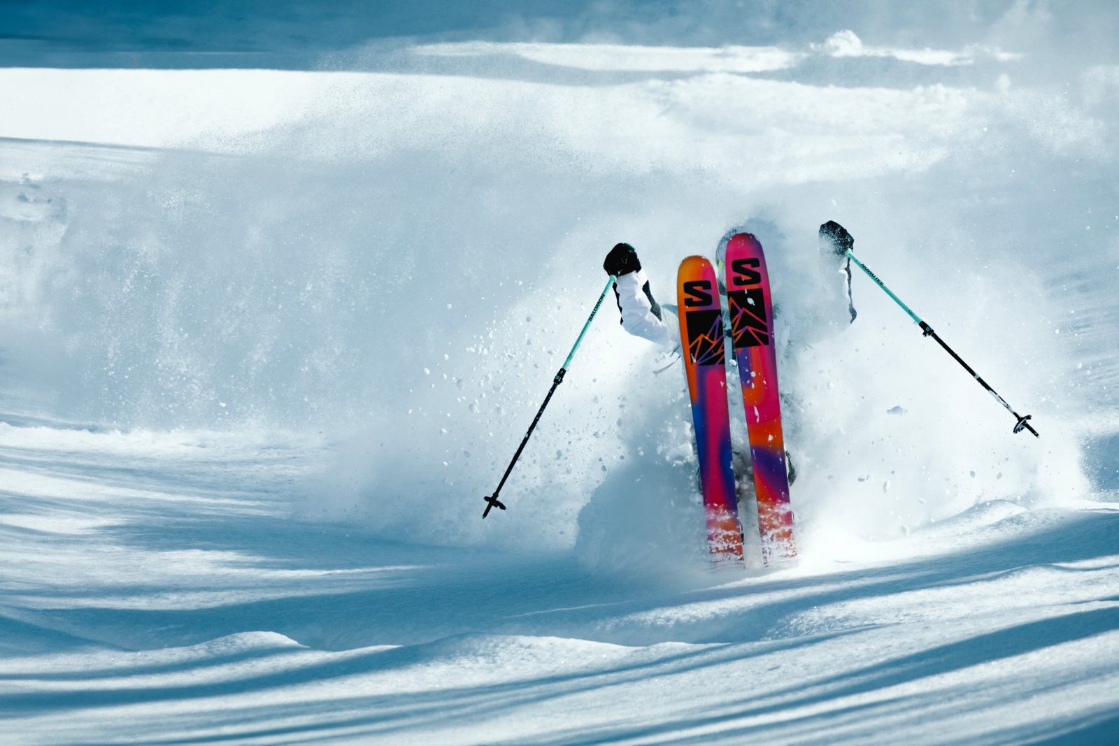 Skier buried in powder with skis in the air