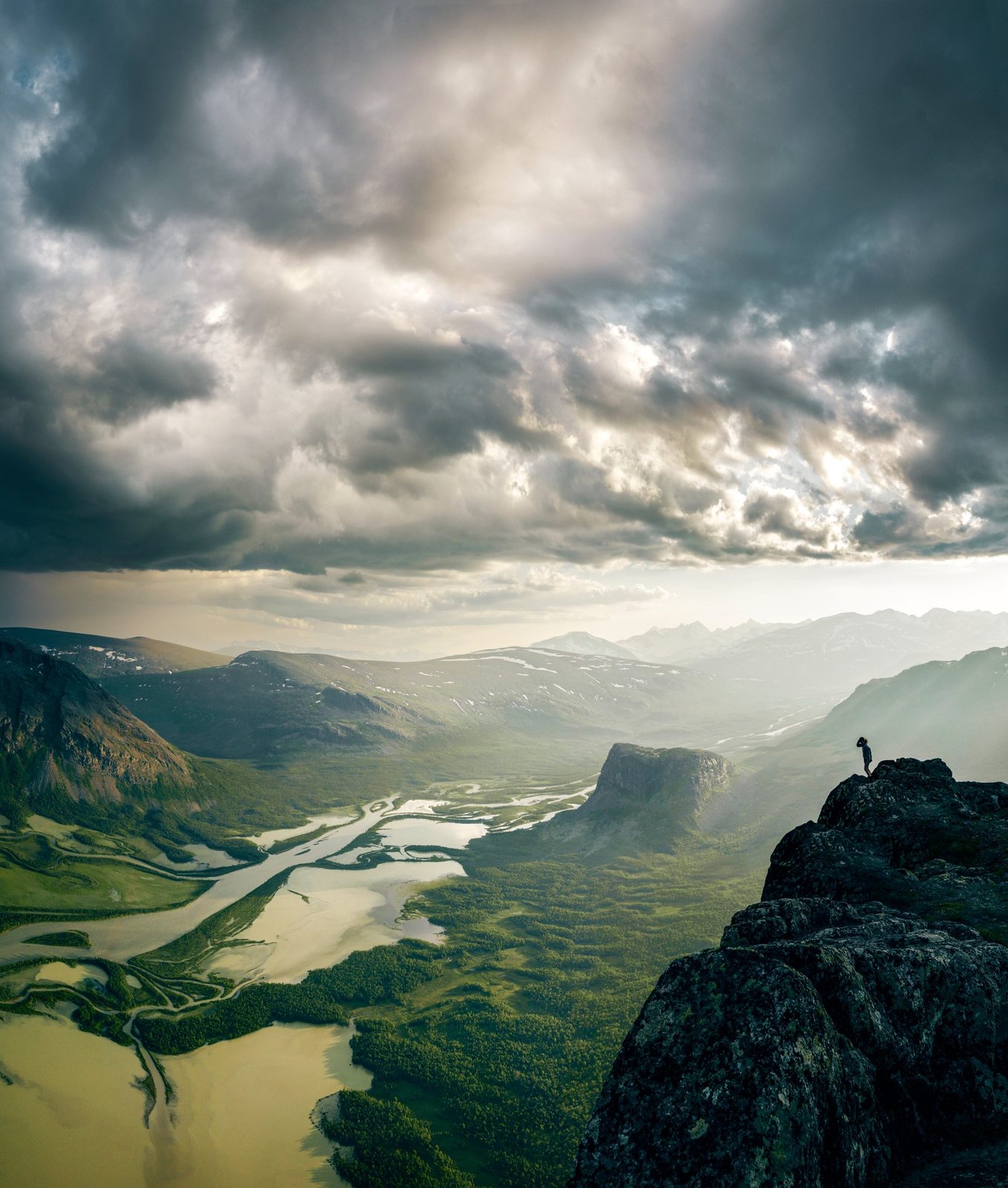 Hiker above a river delta in Sarek